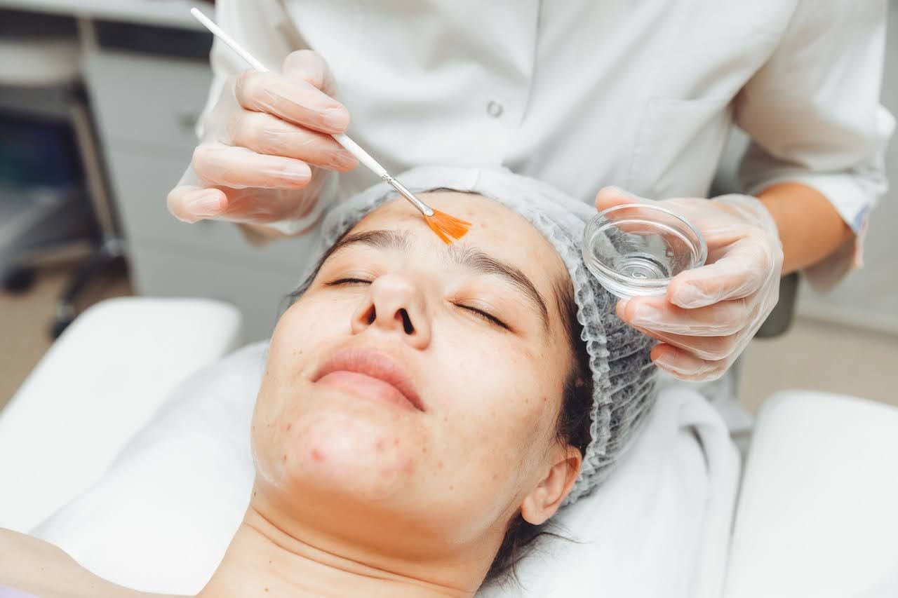 Skincare professional applying a face masque during a facial treatment