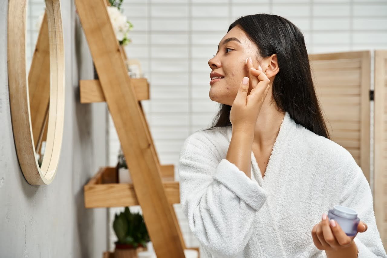 Woman applying acne treatment