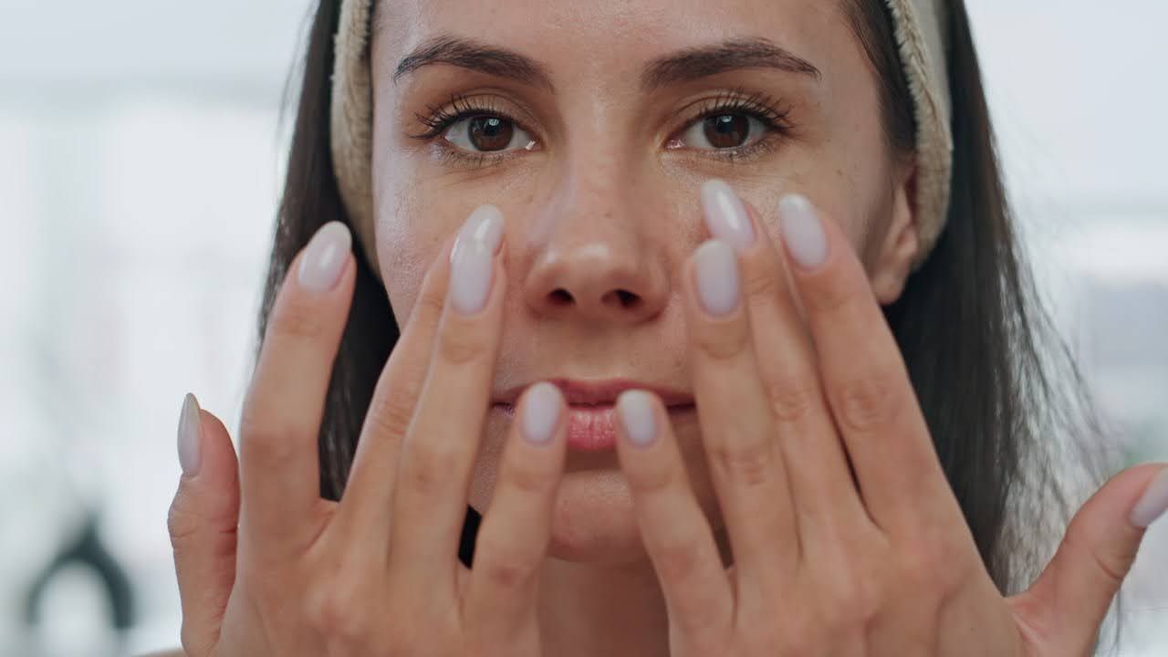 Woman applying serum to face
