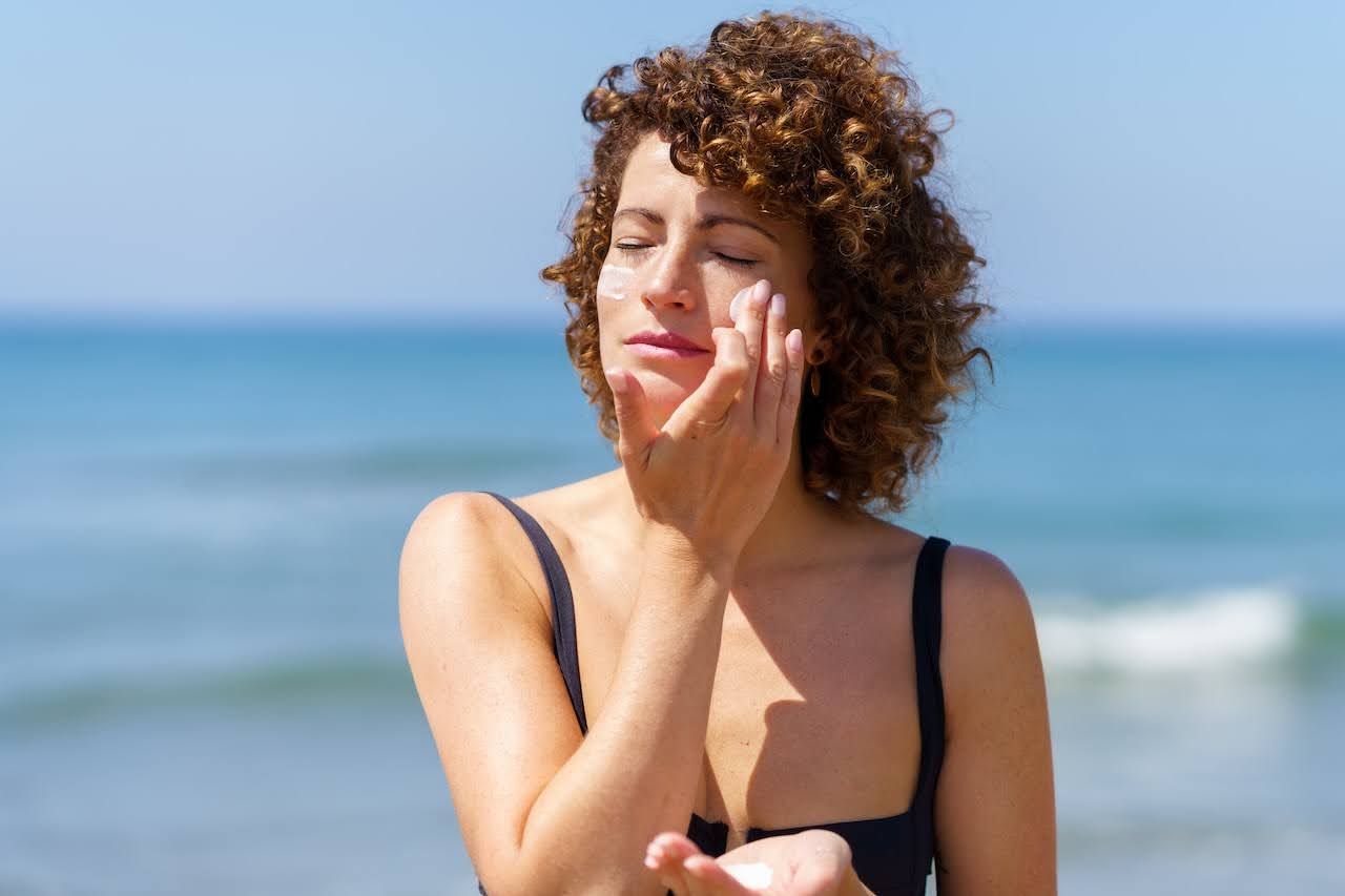 Woman applying sunscreen to protect skin
