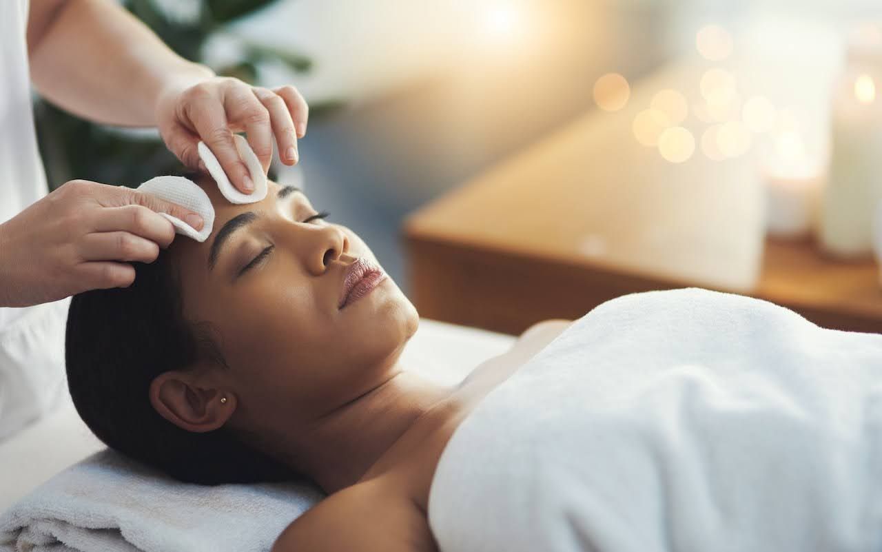 Woman getting facial to help with adult acne