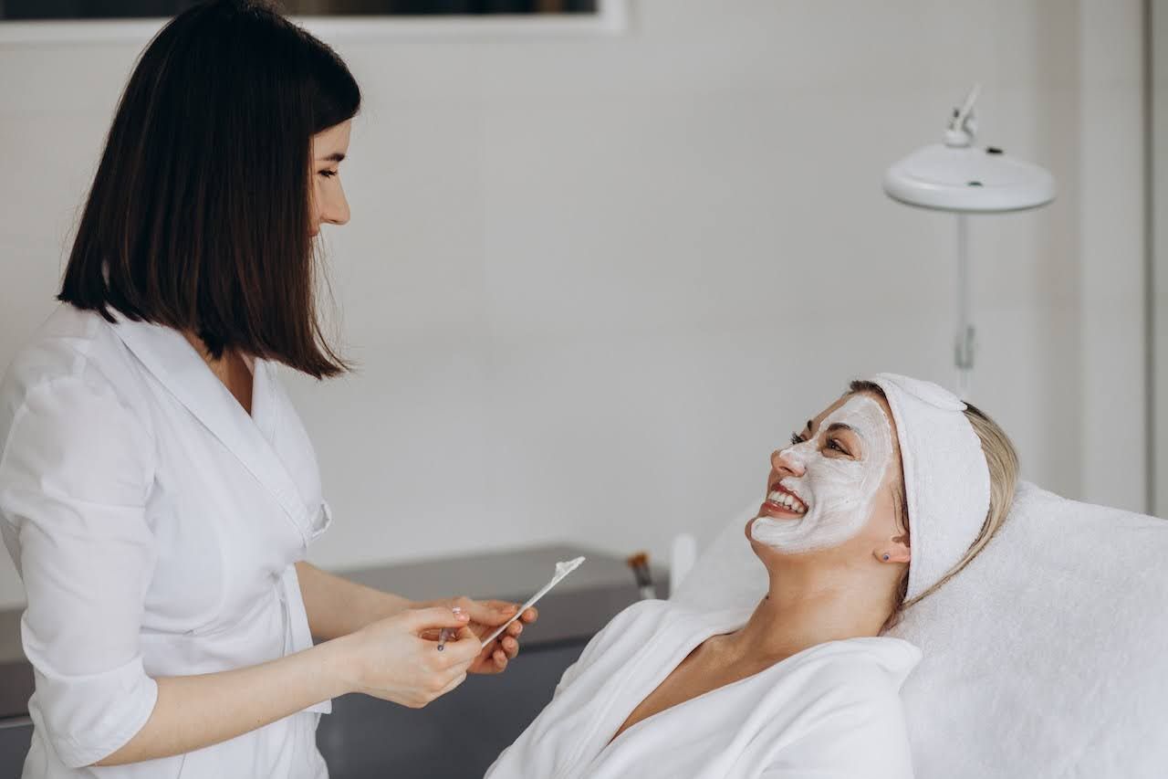 Woman in masque discussing the causes of her dry skin with skin professional