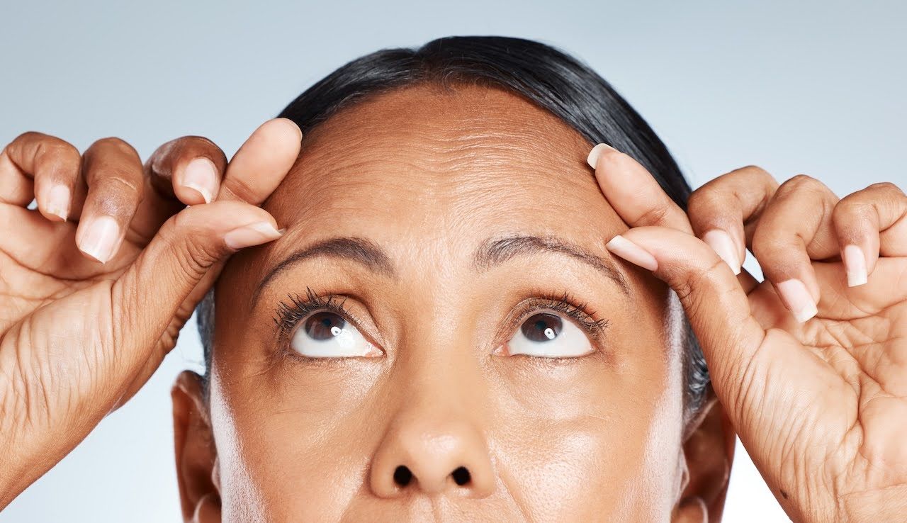 Woman looking at forehead wrinkles
