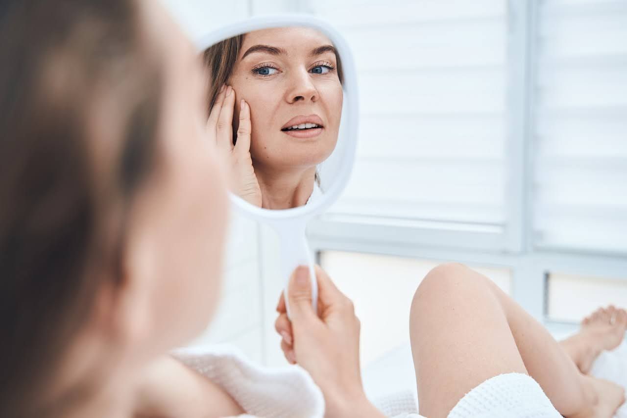 Woman looking at results of microneedling treatment