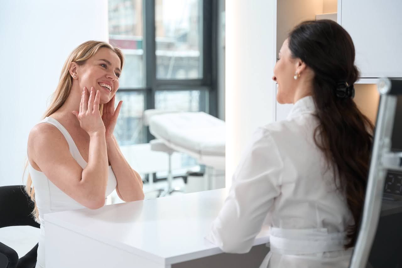 Woman seeing skin professional to assess skin