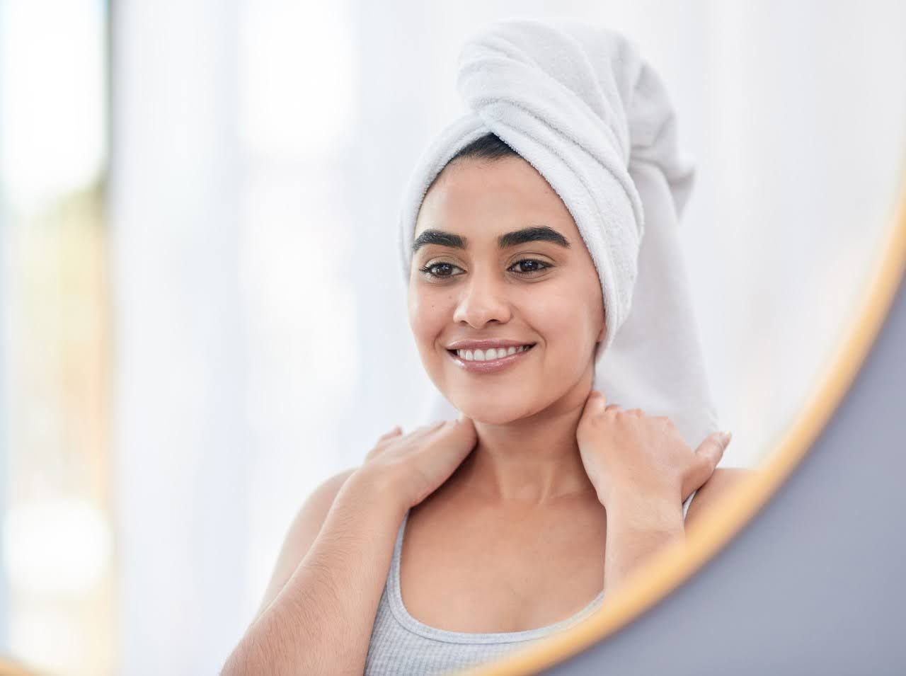 Woman smiling in mirror after nanoneedling