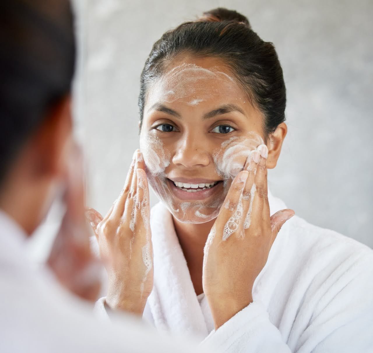 Woman washing her face before applying a face masque