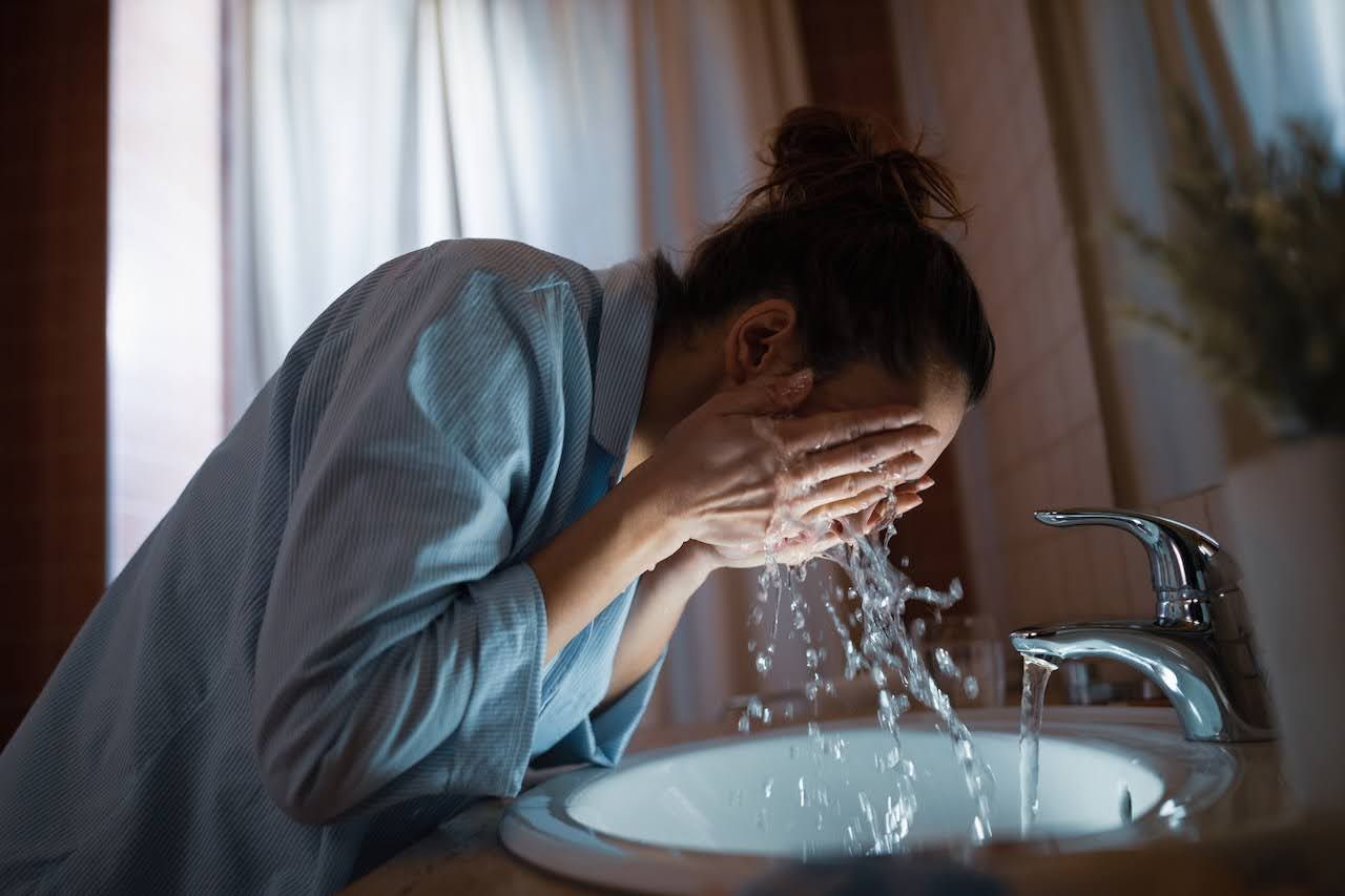 Woman washing her face during nightly skincare routine
