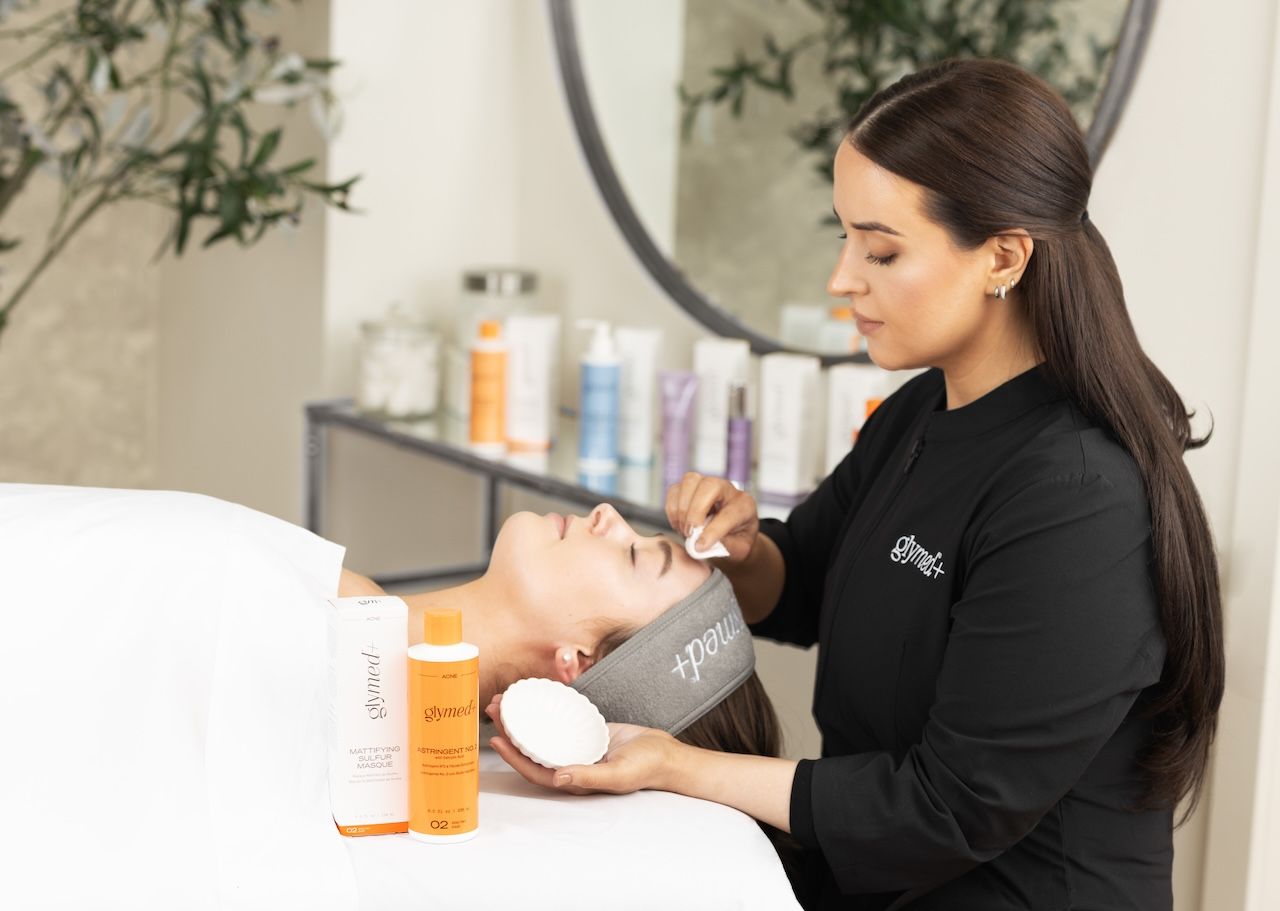 skincare professional performing a facial treatment to address different types of acne