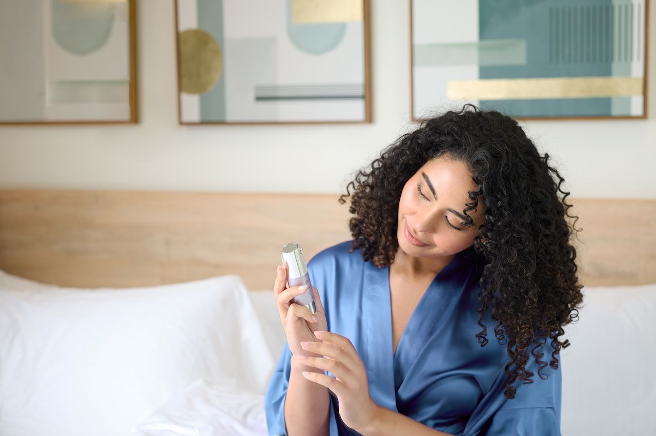 woman applying glymed+ peptide serum as part of an evening skincare routine