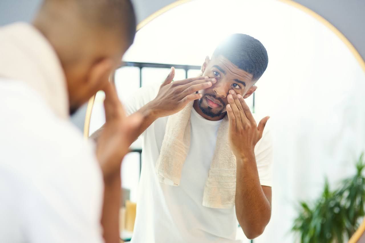 man applying moisturizer to hydrate stressed skin