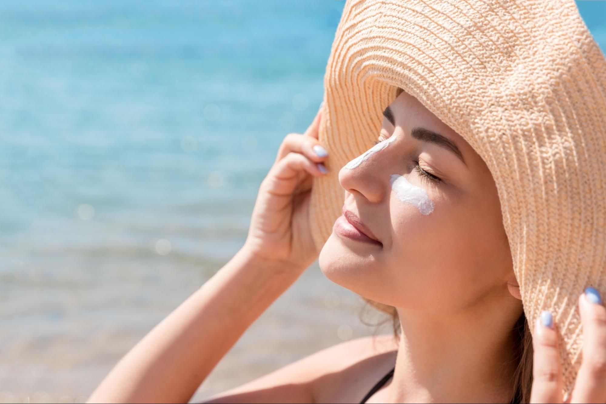 woman applying sunscreen outdoors to protect skin after rf microneedling treatment