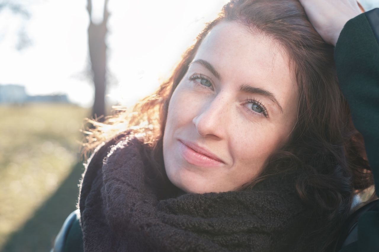 woman with healthy skin outdoors in natural sunlight showing hydrated complexion